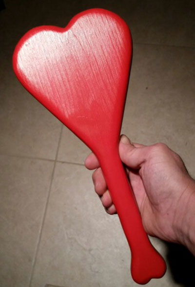 A beautiful heart shaped paddle made out of wood and painted red