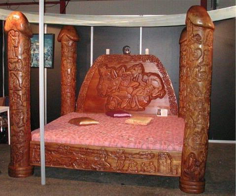 Intricate bed posts are hand carved as phalics.