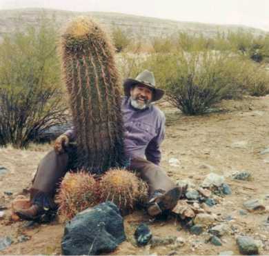 Man has legs around huge cactus aka "male humor"
