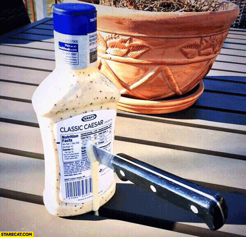 knife stuck in a dripping jar of dressing called "Classic Caesar. 