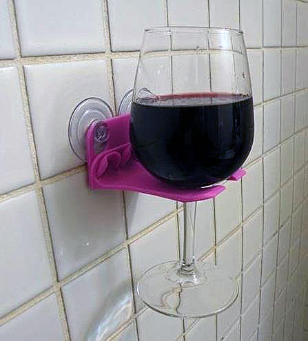 Plastic holder on wall holds a glass of red wine.